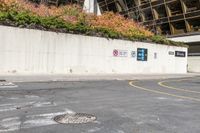 an asphalt lot with a road running down it and a wall near by it that has a parking sign on it