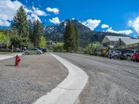 a big house with two fire trucks parked next to it and mountains in the background