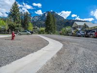 a big house with two fire trucks parked next to it and mountains in the background