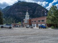 a big house with two fire trucks parked next to it and mountains in the background