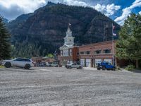 a big house with two fire trucks parked next to it and mountains in the background