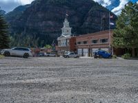 a big house with two fire trucks parked next to it and mountains in the background