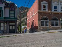 a big house with two fire trucks parked next to it and mountains in the background