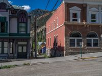 a big house with two fire trucks parked next to it and mountains in the background