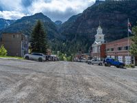 a big house with two fire trucks parked next to it and mountains in the background