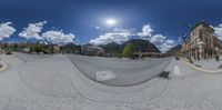 this is a 360 - vr panorama shot taken in mountain town streets, with mountains as background