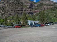 a big house with two fire trucks parked next to it and mountains in the background