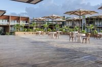 an outdoor bar and restaurant that is surrounded by tables with umbrellas and other outdoor seating