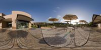 an outdoor cafe with umbrellas in the air and two chairs and tables in the ground