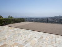 the deck is laid with large blocks of tiles in it and a view of a city