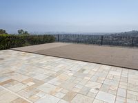 the deck is laid with large blocks of tiles in it and a view of a city