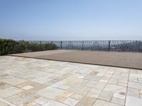 the deck is laid with large blocks of tiles in it and a view of a city