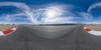the panoramic photo shows the bend at an outdoor race track, as if it is moving