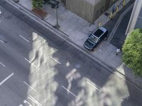 an overhead view shows the parking meters on a busy city street in a shadow - cast image