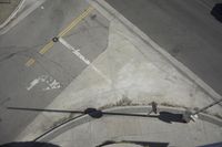 an overhead view shows the intersection at an intersection of two streets and two people crossing