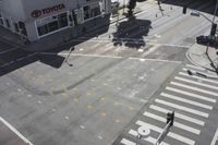 an overhead view shows the intersection at an intersection of two streets and two people crossing