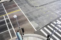 an overhead view shows the intersection at an intersection of two streets and two people crossing