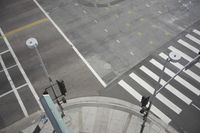 an overhead view shows the intersection at an intersection of two streets and two people crossing