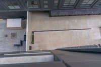 an overhead view of a large building with concrete steps in front and a building that has several windows