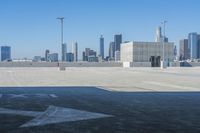 an airplane parked on top of a tarmac surrounded by tall buildings, in the distance