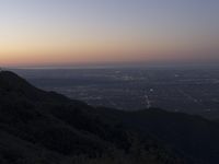 a view of a mountain valley with many mountains in the distance, a bird flies above