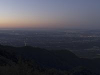 a view of a mountain valley with many mountains in the distance, a bird flies above