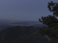 a view of a mountain valley with many mountains in the distance, a bird flies above