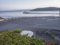 view of the pacific beach from a winding walkway in the distance, with a pier and sea behind