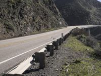 there is a long highway that is on the side of a cliff next to a road