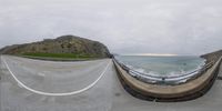 a beach and mountain as seen from a 360 - view camera of a boat approaching a pier