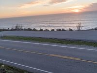 a long road and the ocean and sky during sunset or sunset as seen from above