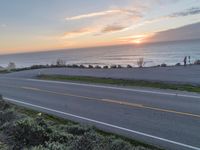 a long road and the ocean and sky during sunset or sunset as seen from above