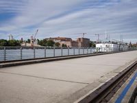 two paddleboats sit in the water near a bridge with a walkway that runs along it