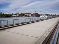 two paddleboats sit in the water near a bridge with a walkway that runs along it