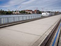 two paddleboats sit in the water near a bridge with a walkway that runs along it