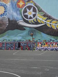 a painted elephant is pictured in front of a building with a wall on it's side