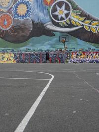 a painted elephant is pictured in front of a building with a wall on it's side