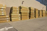 many pallets that are next to a building in the daytime time of the sun