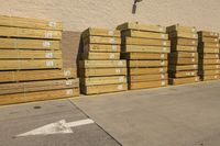 many pallets that are next to a building in the daytime time of the sun