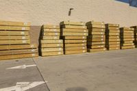 many pallets that are next to a building in the daytime time of the sun