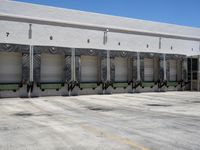 a parking lot with rows of building doors that have six numbers on them and four of which are next to the other