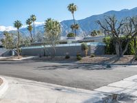 an empty driveway in front of mountains, palm trees and other architecture features throughout the space