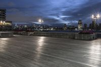 a view of new york city skyline at night from pier on the hudson river side