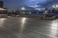 a view of new york city skyline at night from pier on the hudson river side