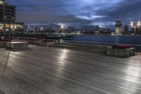 a view of new york city skyline at night from pier on the hudson river side