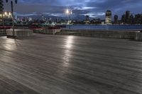 a view of new york city skyline at night from pier on the hudson river side