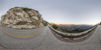 a panoramic view of a paved road in the mountains, taken with a fisheye lens