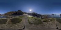 the 360 - pan view is taken in this fish eye lens with the sun setting on top of a mountain