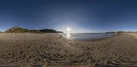 a fisheye panoramic picture with lots of sand and rocks on the side