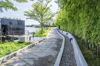 the walkway around a building in an urban area, is lined with plants and trees